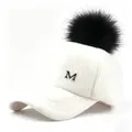 Primer plano de una gorra de béisbol de felpa blanca con pompón negro y un logo M plata - Talla adulto (58CM ajustable) / Gorro Blanco con Pompon Negro