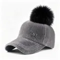 Detalle de gorra de béisbol gris de peluche con pompón negro y logotipo metálico M - Talla adulto (58CM ajustable) / Gris Con Pompón Negro