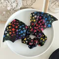 Halloween bat wing bow scrunchie featuring rainbow metallic star patterns on black - Starry Large Bat