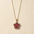 Close-up van een gouden bloemketting met roze kristallen en micro-pavé diamanten details. - Vijfbladige Bloem Ketting / Rozerood