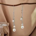 Elegant long silver-tone dangle earrings with white pearls hanging on a branch - E2079-1