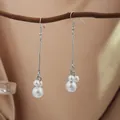 Silver finish drop earrings with clustered white pearls shown on a natural wood branch - E2079-4