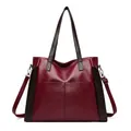 Front view of a stylish burgundy soft leather tote bag featuring dark brown handles and straps - Burgundy