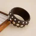 Wide dark brown wooden bangle featuring silver circular metallic studs in various sizes. - Brown-03011