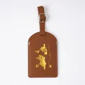 Durable brown PVC luggage tag featuring a golden world map and airplane icon for travel - Luggage Tag Brown