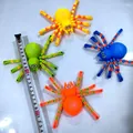 Set mit vier bunten Gelenk-Spinne-Fidget-Spielzeugen mit Maßband zur Größenangabe - Spinne-Stil / 13cm Länge (Im Beutel)