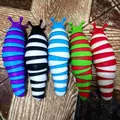 Sammlung von fünf farbenfrohen, beweglichen Fidget-Schnecken-Spielzeugen auf rustikalem Grund - Spitz Zweifarbiger Stil (Ohne Verpackung) / 18.5cm Länge