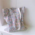 Close-up of a floral canvas tote bag featuring a delicate pink and blue small flower print - Green and Pink Floral
