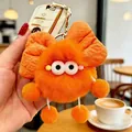 Primo piano di un simpatico ciondolo in peluche arancione con un grande fiocco e occhi - Fiocco arancione