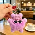 Primo piano del portachiavi mostro peloso viola con cappello rosa e occhiali. - Ciondoli a pallina di fuliggine viola