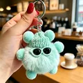 Dettaglio di un portachiavi in peluche spirito del carbone verde menta con cappello. - Ciondoli a pallina di fuliggine ciano