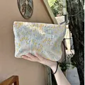 Elegante borsa da trucco beige con ricamo vegetale giallo e blu e etichetta del marchio - Stile Ricamo Floreale / Beige
