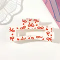 Detail of white claw clip featuring a vibrant red bow and heart pattern design - Style F White / 8.5cm Size