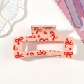 Detailed macro view of a pink hair claw clip featuring red bow and heart patterns - Style F Pink / 8.5cm Size