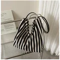 Bolso tote de lona a rayas en estante moderno con una estética minimalista. - Bolso Tote de Hombro / Azul