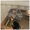 Elegante borsa a secchiello leopardata con tracolla a catena dorata e chiusura a coulisse. - Bianco
