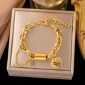 Elegante pulsera de cadena de acero de titanio dorado con un dije de corazón pulido. - Pulsera Doble Cadena Tubo Redondo Corazón (E2544) / Dorado