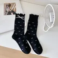 Chaussettes noires élégantes pour femmes avec motifs nœuds blancs et bords à volants - Taille unique / Noir avec Nœud (1 Paire)