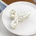 Pince à cheveux blanc crème élégante à pois noirs avec un design de nœud raffiné. - Nœud