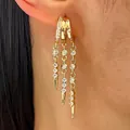 Makro-Detail modischer goldener Creolen mit Zirkonia-Quasten und Punk-Spikes am Ohr - Irreguläre Nietenquaste (DZ-164)