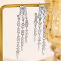 Close-up of silver-tone hoop earrings with zircon tassels and rivet pendant details. - Irregular Tassel Stud Hoop Style (14/9055)