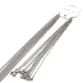 Vista detallata de varias cadenas en O de acero inoxidable plateado en una tarjeta blanca - 1.5mm-40cm / Color acero