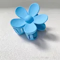 Detailed close-up of a vibrant light blue matte flower hair claw clip for hair styling. - 7.5CM (Bulk) / Sky Blue