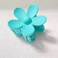 Close-up view of a matte cyan flower hair claw clip on a white surface - 7.5CM (Bulk) / Lake Blue