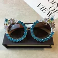 Luxuriöse Cat-Eye-Sonnenbrille für Damen mit blauen Strasssteinen und Blumenakzenten. - Weißer Rahmen / Wasserblauer Strass