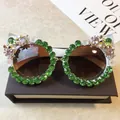 Elegante weiße Cat-Eye-Sonnenbrille mit grünen Kristallen und dekorativen Blumendetails - Weißer Rahmen / Grüner Strass