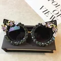 Elegante Cat-Eye-Sonnenbrille mit dunkelgrünen Strasssteinen und feinen rosa Blumendetails - Schwarzer Rahmen / Schwarzgrauer Strass