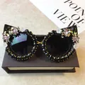Verzierte Cat-Eye-Sonnenbrille mit schwarzen Strasssteinen und rosa floralen Akzenten - Schwarzer Rahmen / Schwarzer Strass