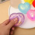 Detailaufnahme eines bunten herzförmigen Glitzer-Quetschspielzeugs zum Stressabbau beim Drücken - Glitzer Pailletten Stil / Glitzer-Maltose-Herz-Squishy