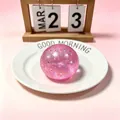 Pink gold glitter maltose squeeze stress ball on a white plate decorative setup - Pink