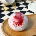 Handmade squishy stress relief toy ball with red ice shard texture on wooden plate - Strawberry Shaved Ice Squishy / Red