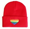 Nahaufnahme der lebhaften Regenbogenherz-Stickerei auf einer roten Strickmütze. - Verstellbar / Buntes Rot