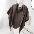 Detailaufnahme eines braunen gestrickten Dreieckstuchs für den Herbst - Dreiecksschal mit Lederschnalle (Oberteil) / Mokka