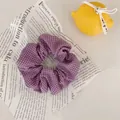Gros plan d'un chouchou à carreaux violets sur papier vintage avec un citron décoratif - Violet Taro Carreaux