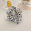 Close-up of French retro floral scrunchie with blue and yellow daisy pattern - Pastoral Orange Flower
