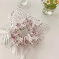 Macro view of vintage floral hair scrunchie with pink rose patterns on white fabric - Pink Rose