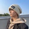 Stylish beige knitted beanie hat for winter with black patch detail for men and women - One Size / Square Tag Style / Beige
