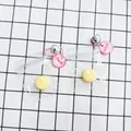 Μικρό κίτρινο μενταγιόν squishy με ροζ αλυσίδα και κουδούνι σε συσκευασία - Μενταγιόν Squishy Σχήμα Μπανάνας
