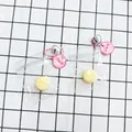 Small yellow squishy pendant toy with pink chain and bell in clear packaging - Banana Shape Squishy Pendant