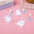 Set of three cute white plush bunny charms featuring purple bows and tinkling bells - Flocked Rabbit Squishy Pendant With Bell