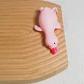 Pink cartoon duck squishy stress relief toy presented on a textured wooden tray background - Large White Duck / Pink