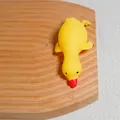 Cute yellow cartoon duck stress relief squeeze toy resting on a textured wooden board - Large White Duck / Yellow