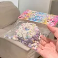 Squishy taro cake stress relief toy in colorful packaging held by hand for detailed view - Purple Cake Squishy