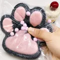 Close-up of squeezing a giant 14cm pink and grey cat paw plush squishy toy for relief. - Black and Pink Flocked