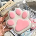 Macro view of a giant 14cm flocked cat paw squishy toy in clear packaging - White and Pink Smooth