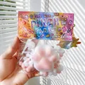 Close-up of rainbow cat paw squishy stress relief toy in colorful packaging. - White Plush